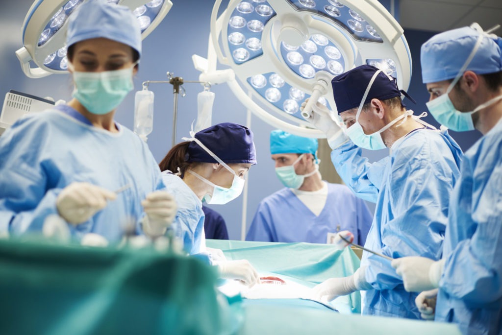 Symbolbild: Ärzte um einen Patienten vor einer Operation - Bild: gpointstudio - Adobe Stock