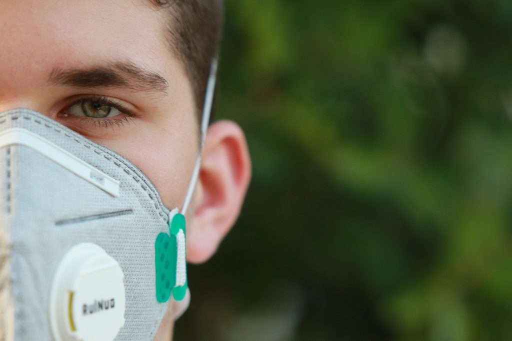 Symbolbild: Junger Mann mit Atemschutzmaske
