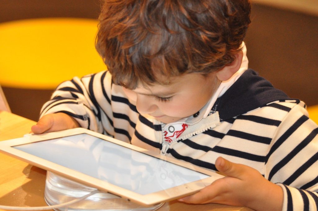 Symbolbild: Kind spielt auf Tablet