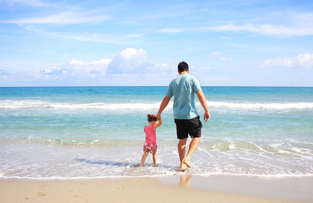 Symbolbild: Urlaub - Kind mit Vater am Strand