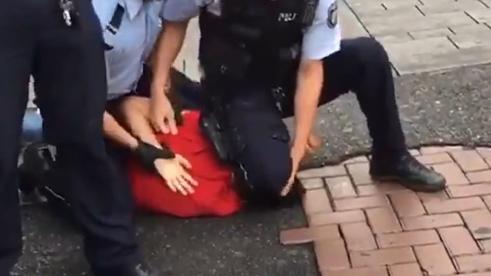 Polizei kniet auf dem Genick eines Passanten - Bild: Twitter
