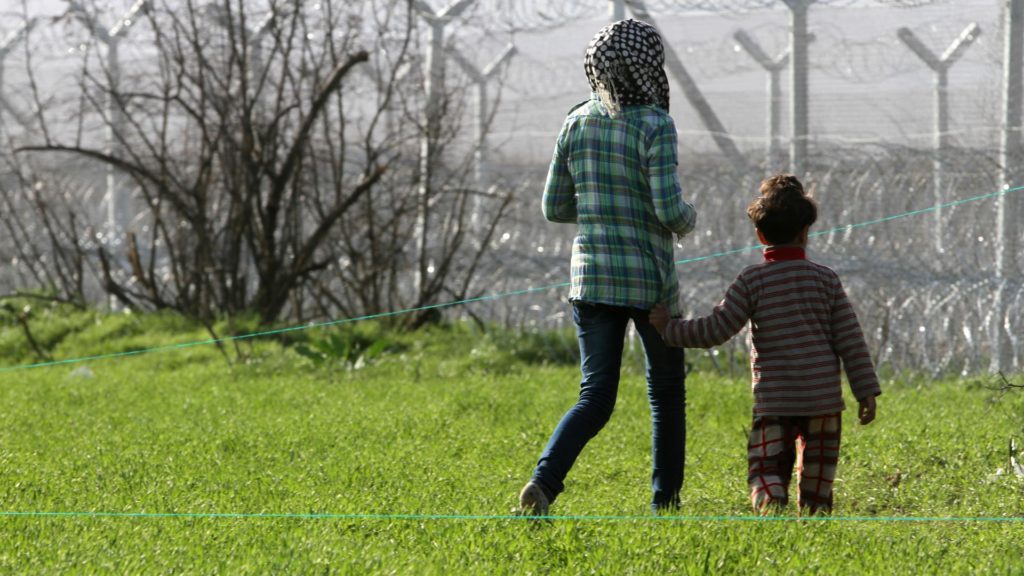 Flüchtlinge vor einem Grenzzaun (über dts Nachrichtenagentur)