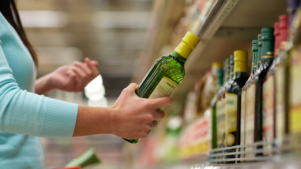 Kundin mit Olivenölflasche im Supermarkt (über cozmo news)