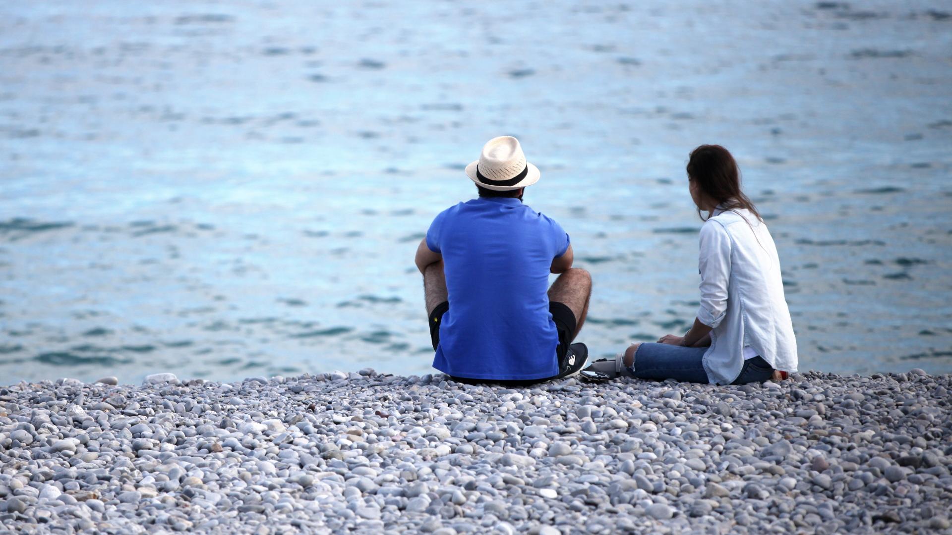Mann und Frau sitzen am Strand (über dts Nachrichtenagentur)