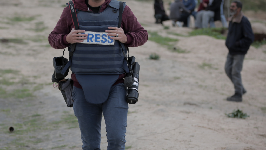 Journalist mit Schutzweste im Kriegsgebiet (über cozmo news)