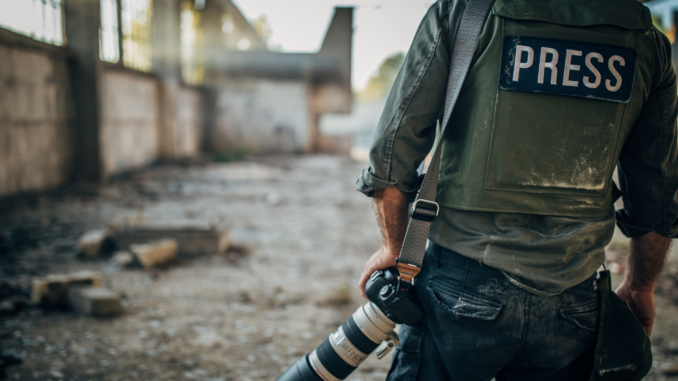 Journalist mit Schutzweste im Kriegsgebiet (über cozmo news)