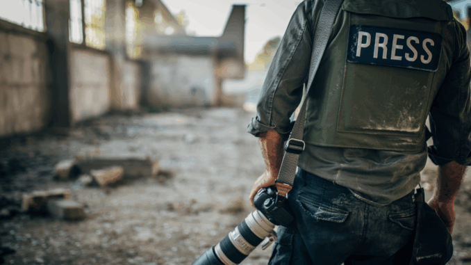 Journalist mit Schutzweste im Kriegsgebiet (über cozmo news)